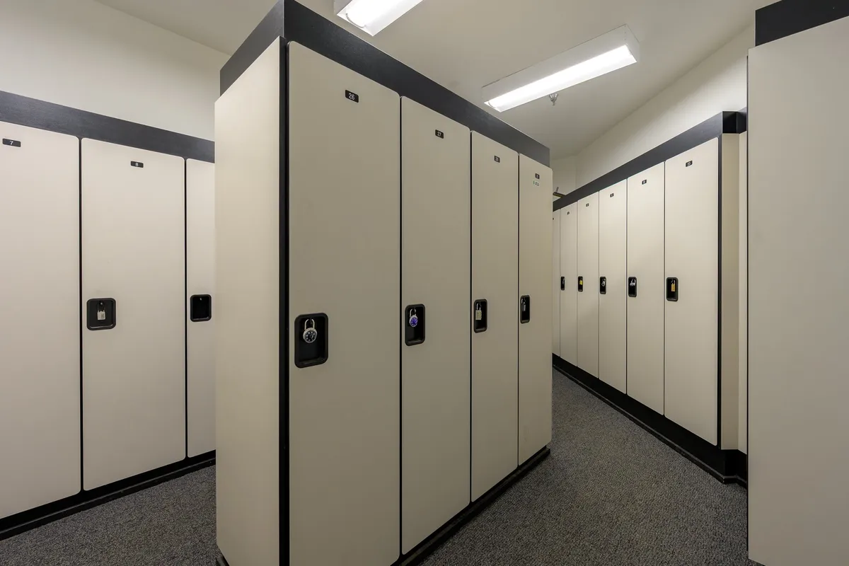 A well-lit, organized locker area with clean flooring and individual storage units. The mood is functional and secure, suitable for storing ski or bike equipment safely after a day outdoors.